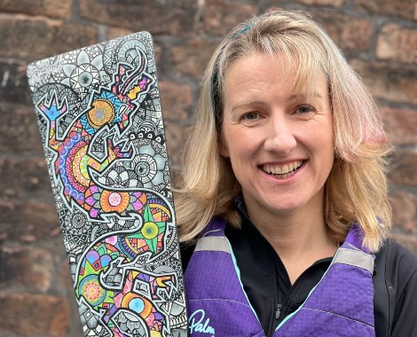 Dr Niamh Malone from Liverpool Hope University standing with her dragon boat racing paddle.